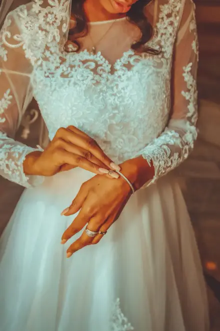 Manos de una novia sobre su vestido de encaje